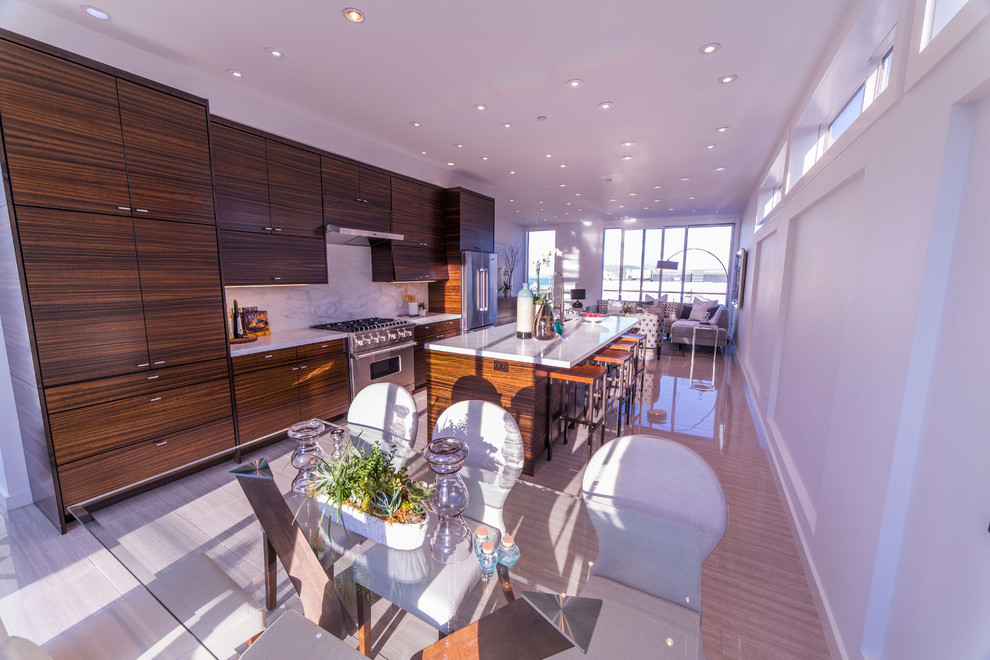 This is an example of an expansive contemporary single-wall kitchen/diner in San Francisco with a built-in sink, flat-panel cabinets, dark wood cabinets, marble worktops, white splashback, stone slab splashback, stainless steel appliances, light hardwood flooring and an island.