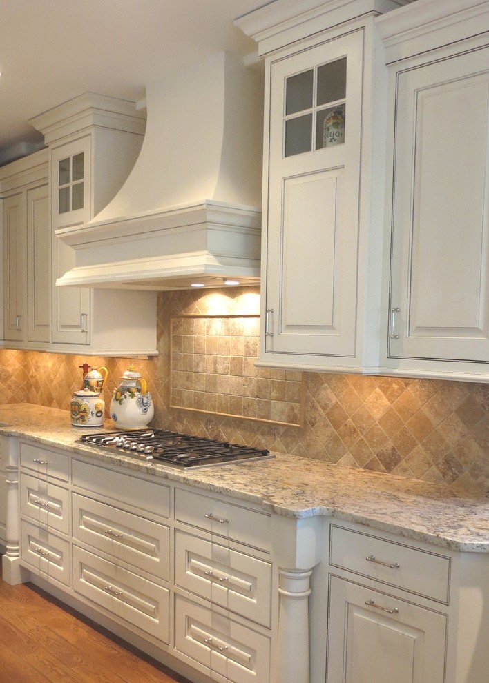 Inspiration for a large traditional kitchen in Denver with beaded cabinets, white cabinets, granite worktops, beige splashback, stainless steel appliances, medium hardwood flooring and an island.