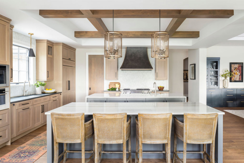 Inspiration for a large transitional l-shaped light wood floor, beige floor and coffered ceiling eat-in kitchen remodel in Denver with a farmhouse sink, recessed-panel cabinets, light wood cabinets, quartzite countertops, white backsplash, matchstick tile backsplash, stainless steel appliances, two islands and white countertops