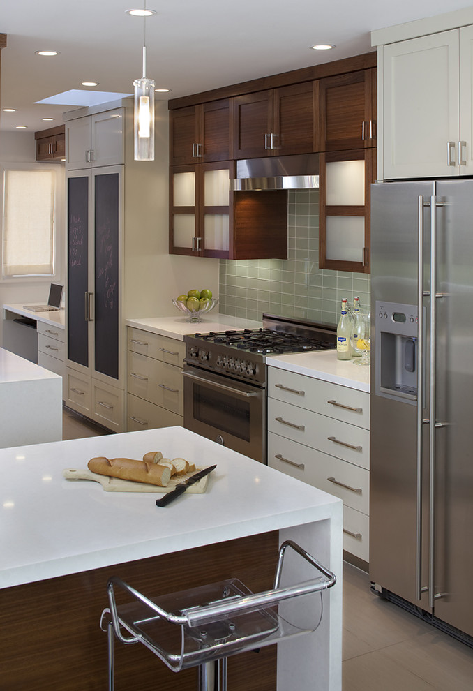 Diseño de cocina contemporánea con armarios con paneles lisos, puertas de armario beige, salpicadero gris, electrodomésticos de acero inoxidable y barras de cocina