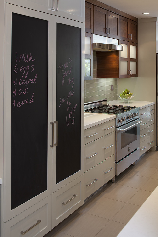 Idée de décoration pour une cuisine encastrable design avec un placard à porte plane et des portes de placard blanches.