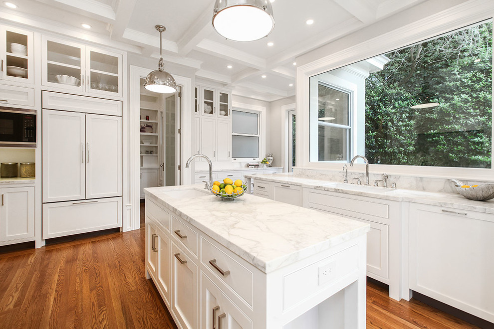 Expansive traditional galley enclosed kitchen in San Francisco with a single-bowl sink, shaker cabinets, white cabinets, white splashback, stainless steel appliances, medium hardwood flooring, an island, marble worktops and marble splashback.