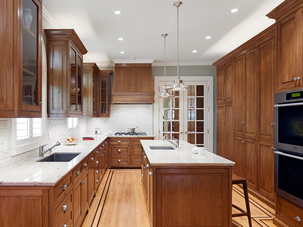 Inspiration for a timeless kitchen remodel in San Francisco with subway tile backsplash, an undermount sink, raised-panel cabinets, dark wood cabinets, white backsplash and granite countertops