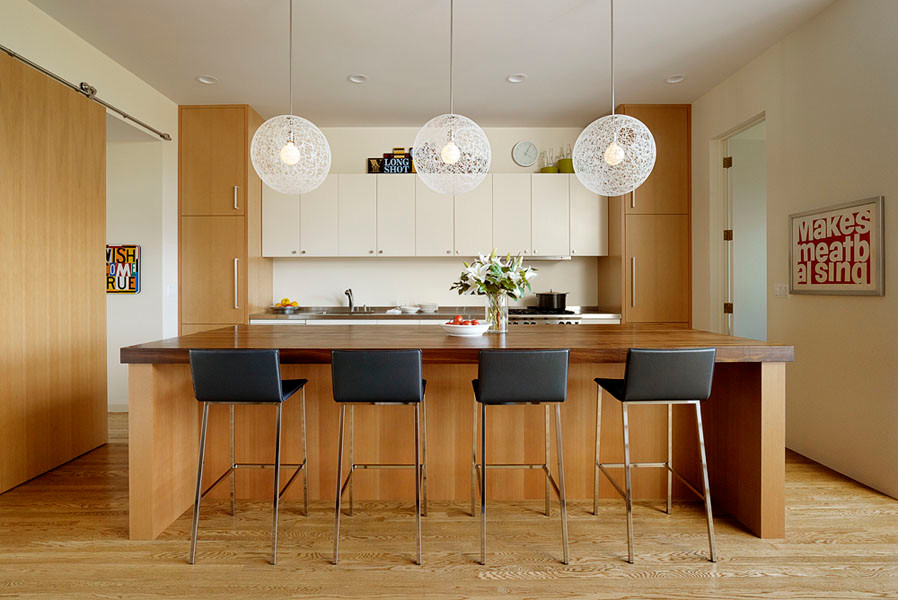 Foto di una grande cucina minimal con ante lisce, ante in legno scuro, top in legno, pavimento in legno massello medio e elettrodomestici da incasso