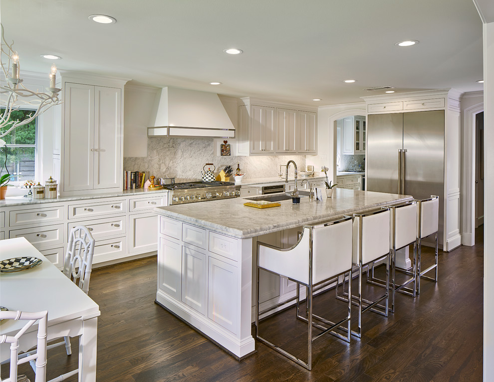 Large transitional l-shaped dark wood floor and brown floor eat-in kitchen photo in Dallas with an undermount sink, shaker cabinets, white cabinets, marble countertops, stone slab backsplash, stainless steel appliances, an island, white backsplash and gray countertops