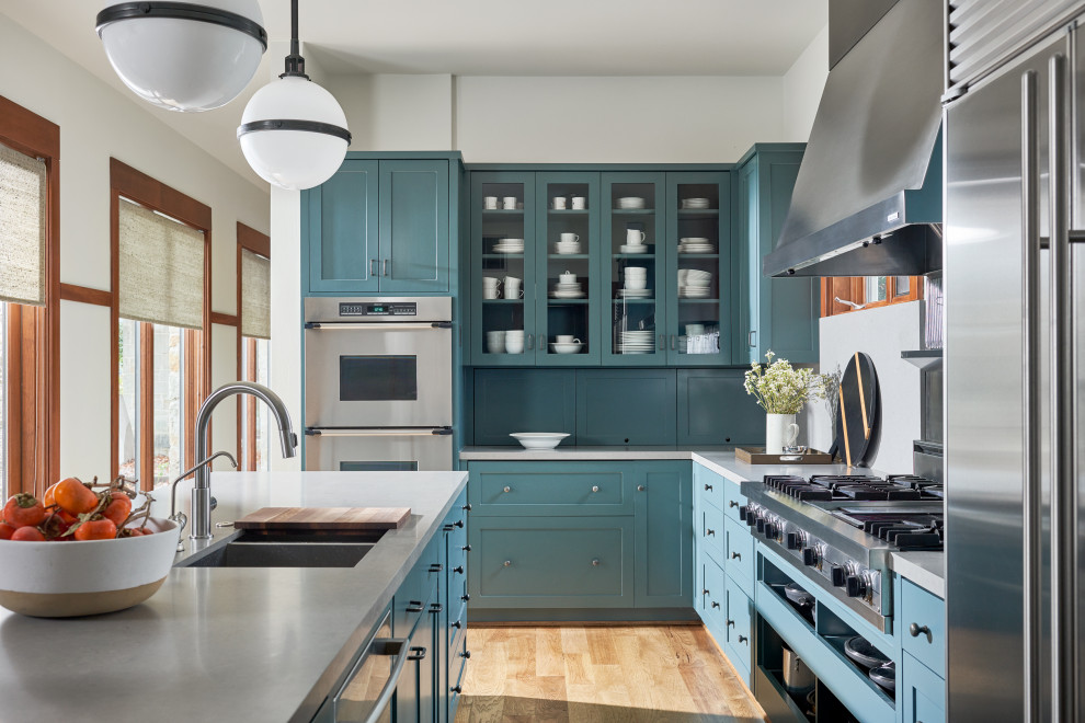 Ejemplo de cocina clásica renovada con puertas de armario azules, encimera de cuarcita y encimeras grises