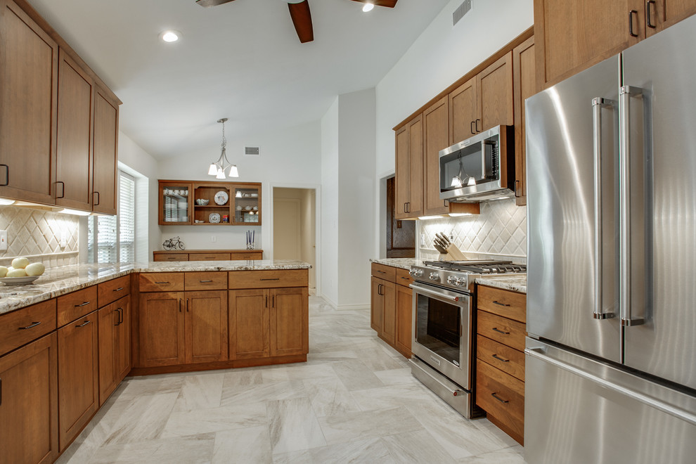 Bild på ett mellanstort amerikanskt kök, med en undermonterad diskho, skåp i shakerstil, skåp i mellenmörkt trä, granitbänkskiva, beige stänkskydd, stänkskydd i stenkakel, rostfria vitvaror, klinkergolv i porslin, en halv köksö och beiget golv