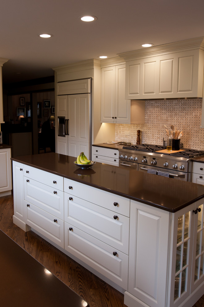 Example of a large classic u-shaped medium tone wood floor and brown floor eat-in kitchen design in Chicago with an undermount sink, raised-panel cabinets, white cabinets, quartz countertops, an island, white backsplash, mosaic tile backsplash and white appliances