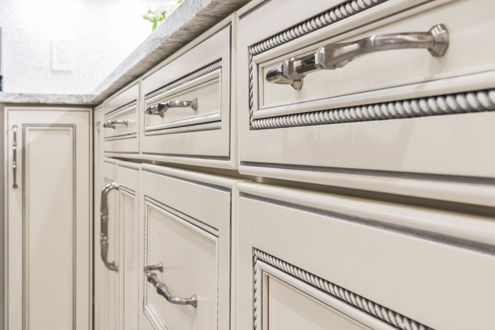 Immagine di una grande cucina classica con ante con bugna sagomata, ante bianche, top in quarzo composito, paraspruzzi bianco e paraspruzzi in marmo