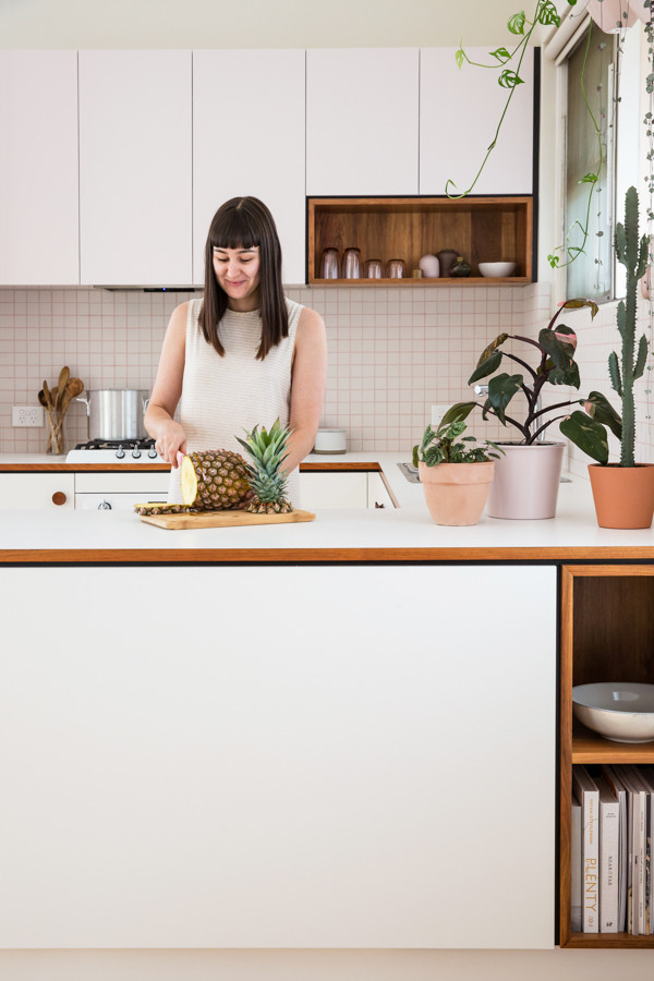 Foto di una piccola cucina minimalista con ante lisce, top in laminato, paraspruzzi bianco, paraspruzzi con piastrelle in ceramica, elettrodomestici bianchi e parquet chiaro
