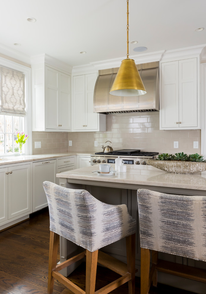 Inspiration for a transitional l-shaped dark wood floor and brown floor kitchen remodel in Charlotte with shaker cabinets, white cabinets, beige backsplash, subway tile backsplash, stainless steel appliances, an island and beige countertops