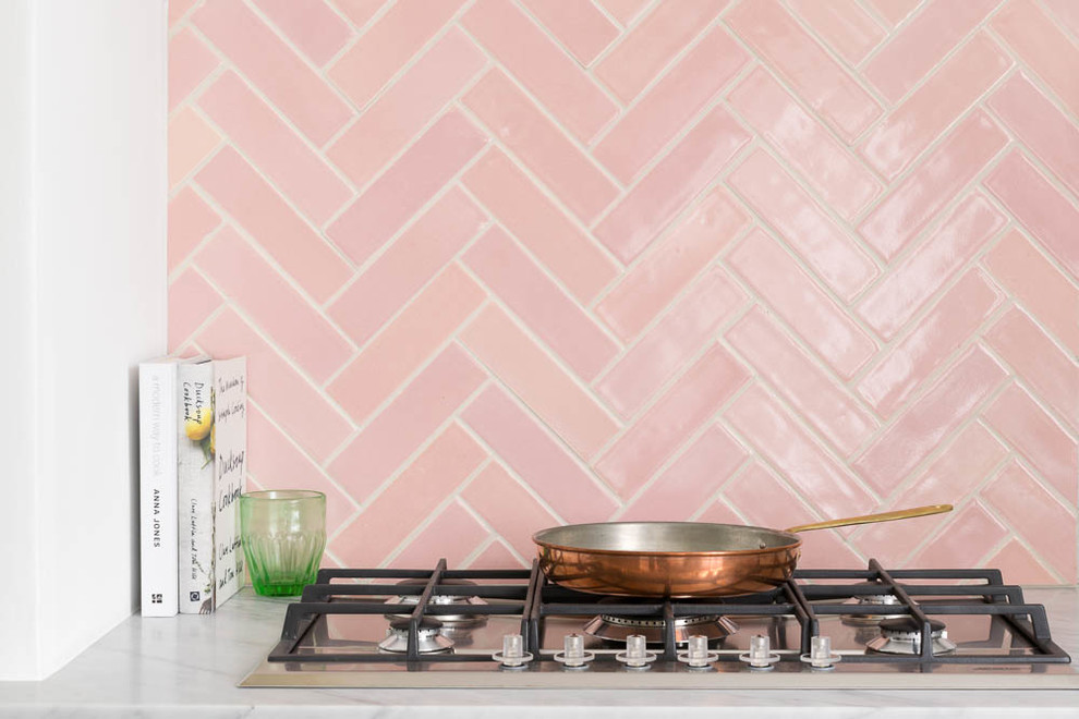 Inredning av ett vit vitt kök och matrum, med marmorbänkskiva, rosa stänkskydd och stänkskydd i keramik