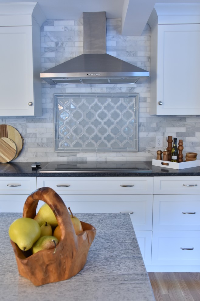 Exempel på ett klassiskt kök och matrum, med en rustik diskho, luckor med infälld panel, vita skåp, granitbänkskiva, stänkskydd i marmor, rostfria vitvaror, ljust trägolv och en köksö