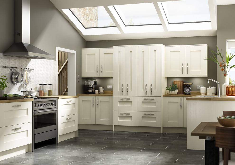 This is an example of a large contemporary galley kitchen/diner in Wiltshire with a submerged sink, recessed-panel cabinets, white cabinets, wood worktops, wood splashback, stainless steel appliances, concrete flooring and no island.