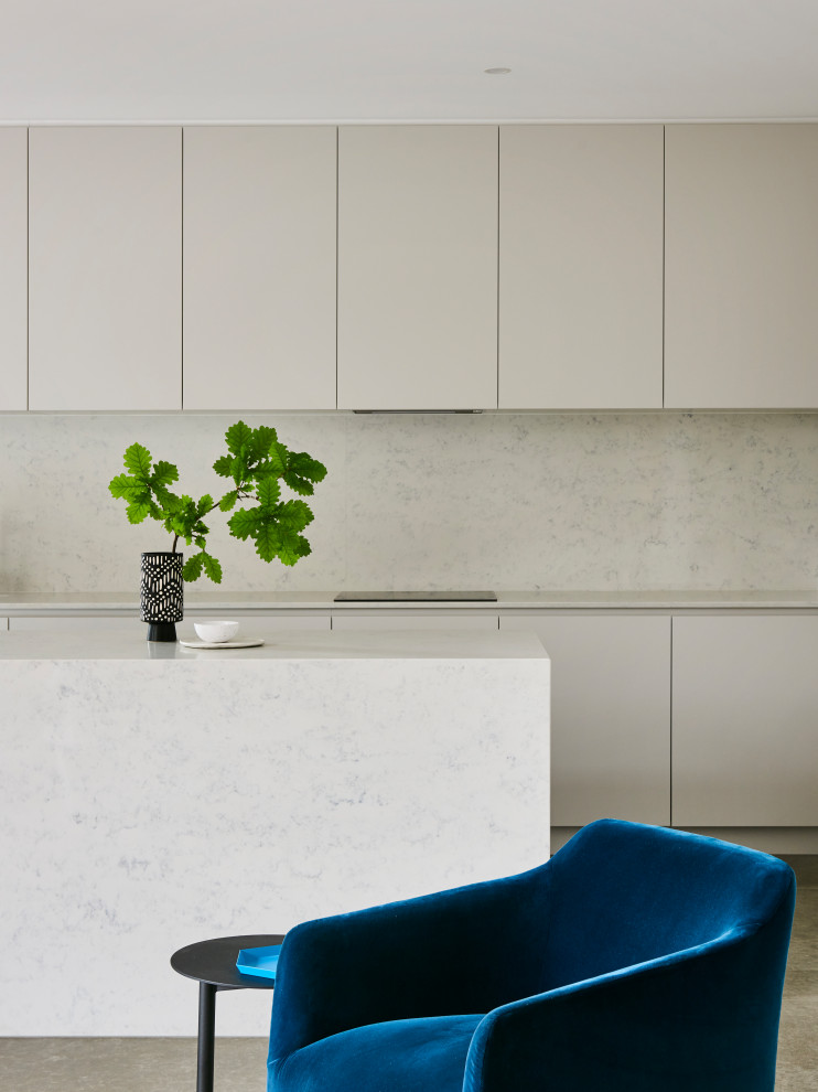 Immagine di una cucina moderna di medie dimensioni con ante lisce, ante grigie, top in quarzo composito, paraspruzzi bianco, paraspruzzi con piastrelle in pietra, pavimento in cemento, pavimento grigio e top bianco