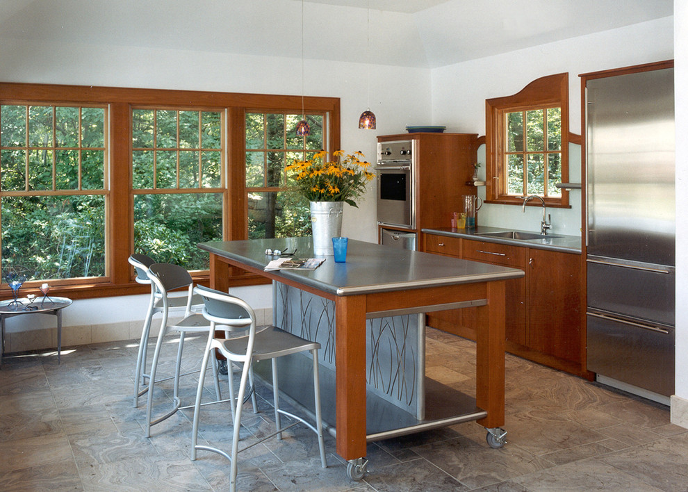 Bild på ett funkis linjärt kök, med rostfria vitvaror, bänkskiva i rostfritt stål, en integrerad diskho, släta luckor, skåp i mörkt trä, klinkergolv i keramik, en köksö och brunt golv