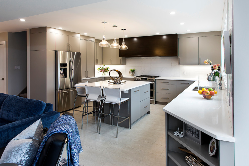 Modern inredning av ett kök, med en dubbel diskho, släta luckor, grå skåp, vitt stänkskydd, rostfria vitvaror, en köksö och beiget golv