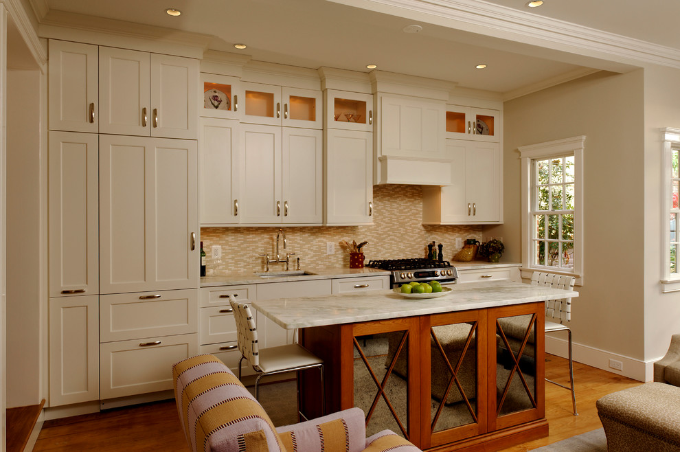 Diseño de cocina lineal tradicional abierta con armarios con paneles empotrados, puertas de armario beige, salpicadero beige, salpicadero de azulejos en listel y electrodomésticos con paneles