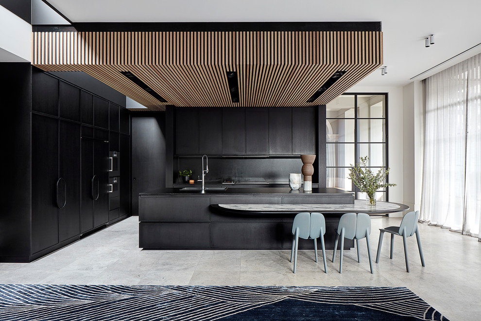 Modern inredning av ett mycket stort svart svart kök med öppen planlösning, med en dubbel diskho, skåp i shakerstil, svarta skåp, granitbänkskiva, svart stänkskydd, stänkskydd i sten, svarta vitvaror, kalkstensgolv, en köksö och grått golv