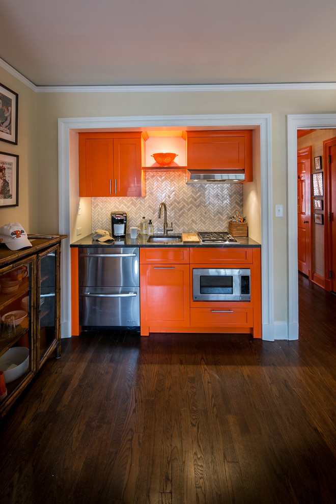Idéer för att renovera ett litet eklektiskt grå linjärt grått kök med öppen planlösning, med en undermonterad diskho, skåp i shakerstil, orange skåp, granitbänkskiva, grått stänkskydd, stänkskydd i marmor, rostfria vitvaror, mörkt trägolv och brunt golv
