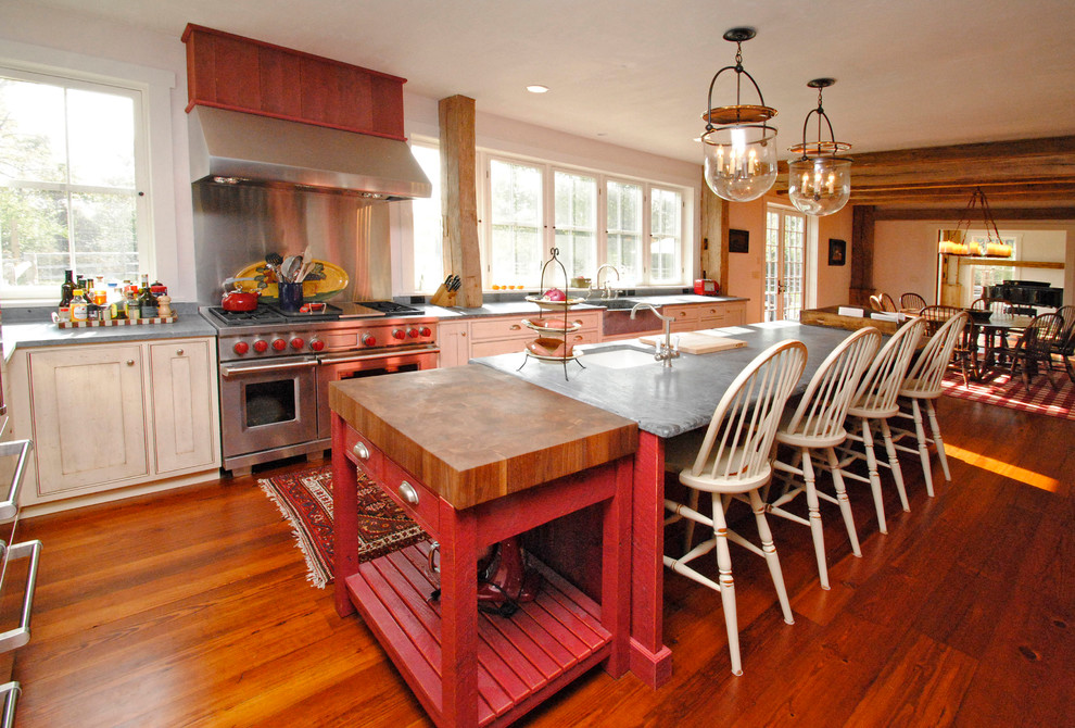 Example of a large country l-shaped dark wood floor eat-in kitchen design in Philadelphia with a farmhouse sink, shaker cabinets, white cabinets, stainless steel appliances, metallic backsplash, granite countertops and an island