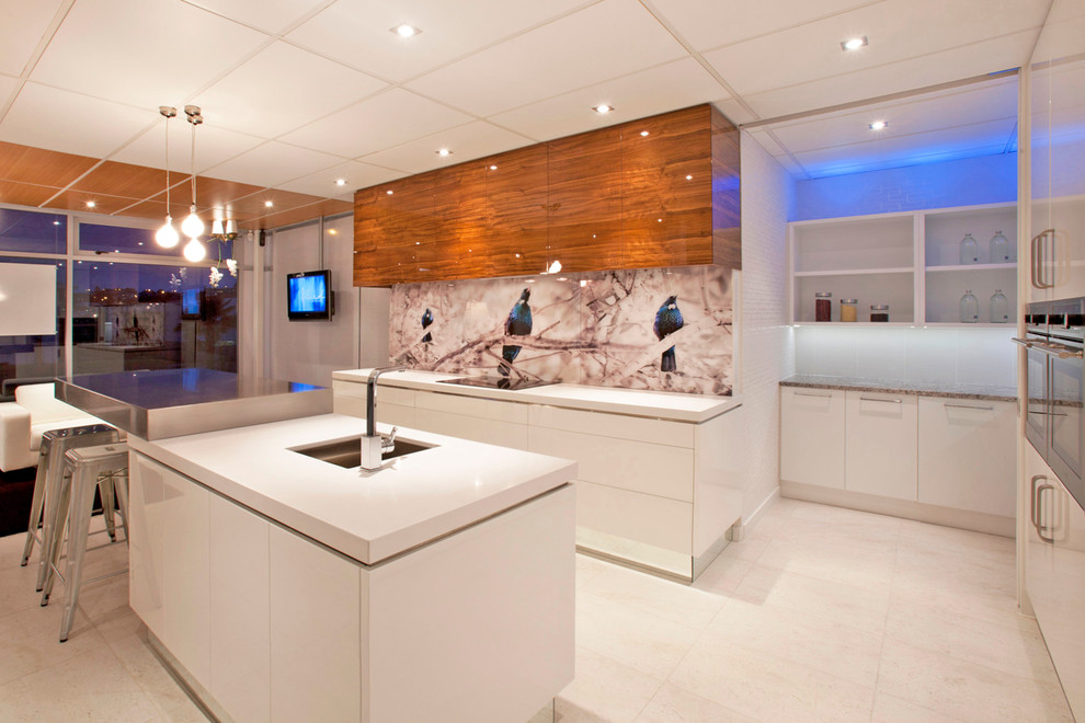 Moderne Küche mit flächenbündigen Schrankfronten, weißen Schränken, bunter Rückwand und Glasrückwand in Auckland