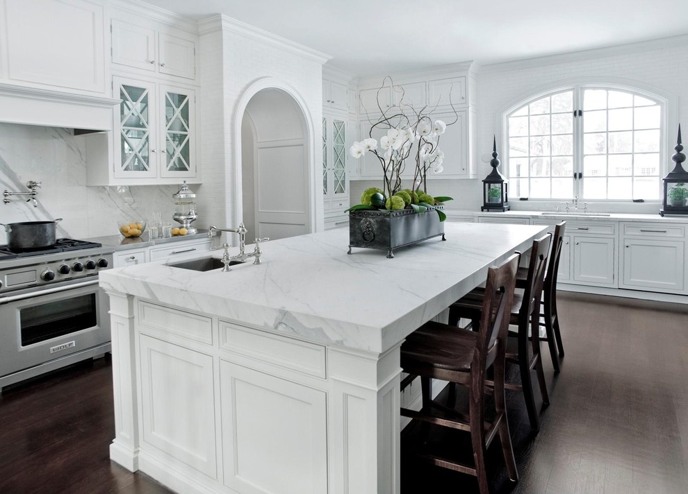 Foto di una cucina tradizionale con ante a filo, elettrodomestici in acciaio inossidabile, top in marmo, ante bianche, paraspruzzi bianco e top grigio