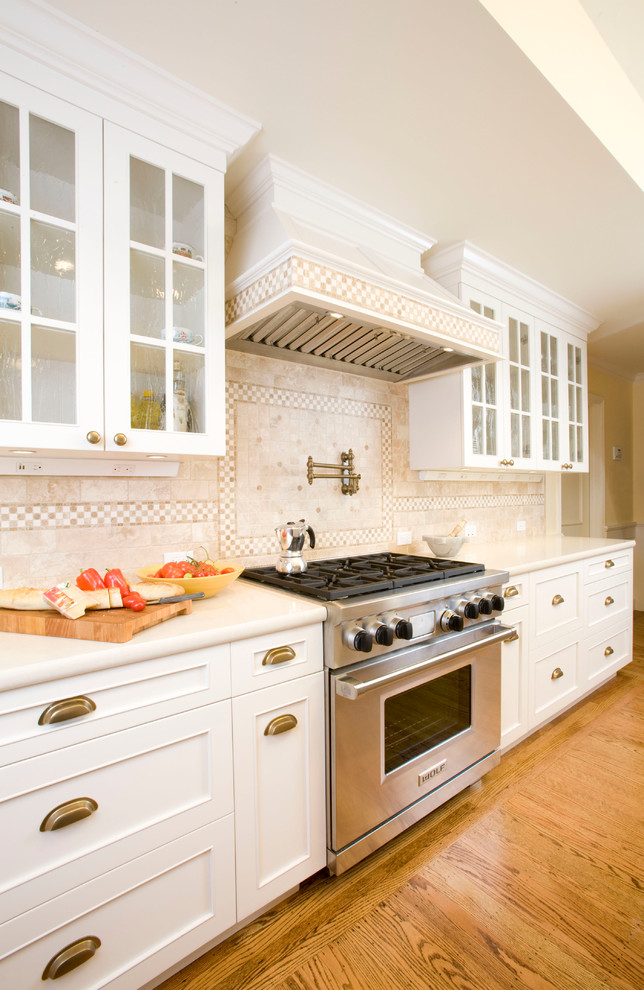 Bild på ett stort beige beige kök, med en undermonterad diskho, skåp i shakerstil, vita skåp, bänkskiva i kvarts, beige stänkskydd, stänkskydd i keramik, integrerade vitvaror, mellanmörkt trägolv, en köksö och brunt golv
