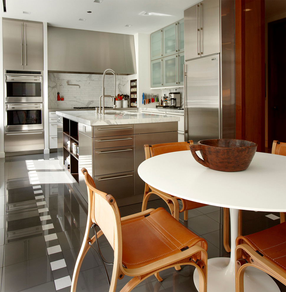 Immagine di una cucina design con ante lisce, ante in acciaio inossidabile, paraspruzzi bianco e elettrodomestici in acciaio inossidabile