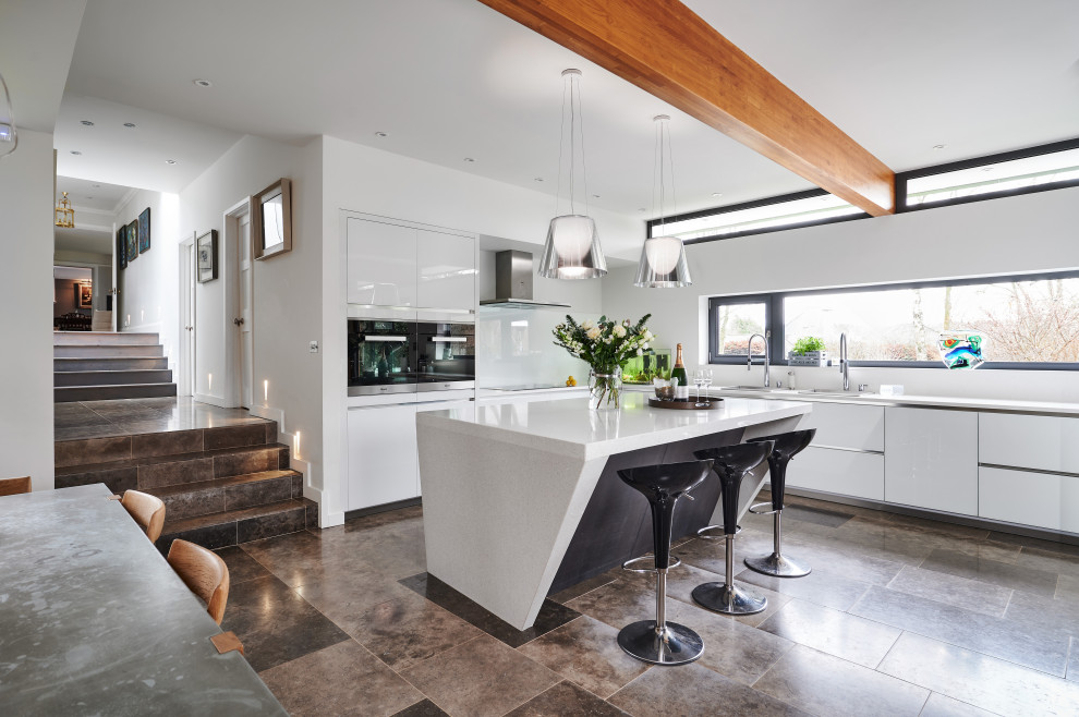 Design ideas for a large contemporary l-shaped kitchen/diner in Other with a submerged sink, flat-panel cabinets, white cabinets, glass sheet splashback, integrated appliances, an island, grey floors and white worktops.