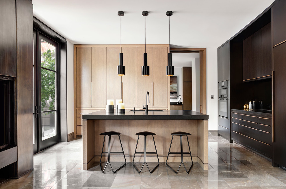 Inspiration for a contemporary u-shaped kitchen in Toronto with a submerged sink, flat-panel cabinets, dark wood cabinets, black appliances, an island, beige floors and black worktops.