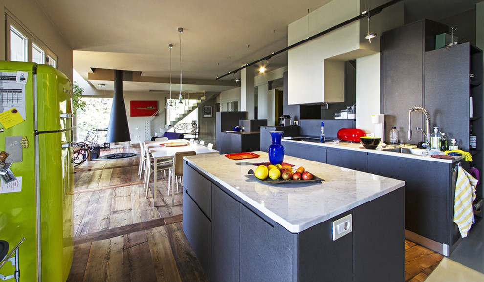 На фото: большая прямая кухня-гостиная в современном стиле с накладной мойкой, плоскими фасадами, серыми фасадами, мраморной столешницей, паркетным полом среднего тона и островом с