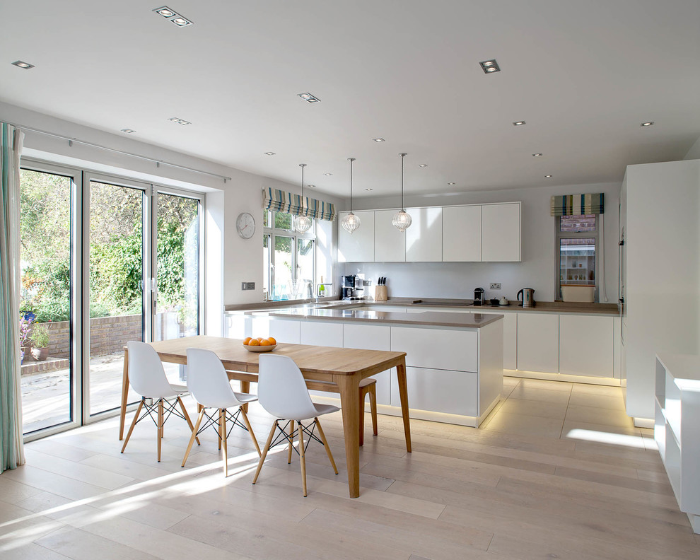 Foto di una cucina nordica di medie dimensioni con lavello sottopiano, ante lisce, ante bianche e parquet chiaro