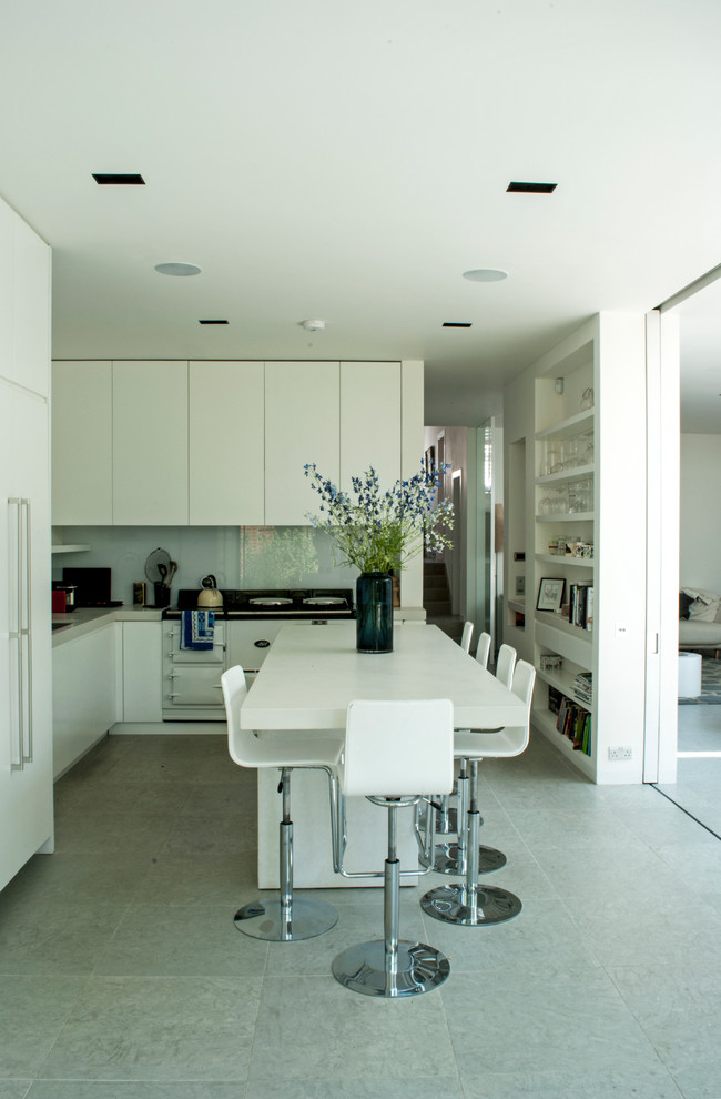 Exempel på ett modernt l-kök, med släta luckor, vita skåp, vitt stänkskydd, glaspanel som stänkskydd, vita vitvaror och en köksö