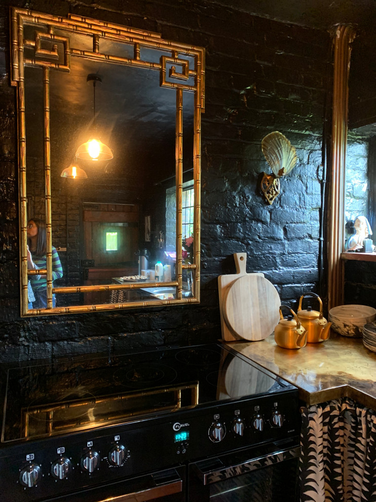 Geschlossene, Kleine Rustikale Küche in U-Form mit Küchenrückwand in Schwarz, schwarzen Elektrogeräten, Backsteinboden und rotem Boden in Sussex