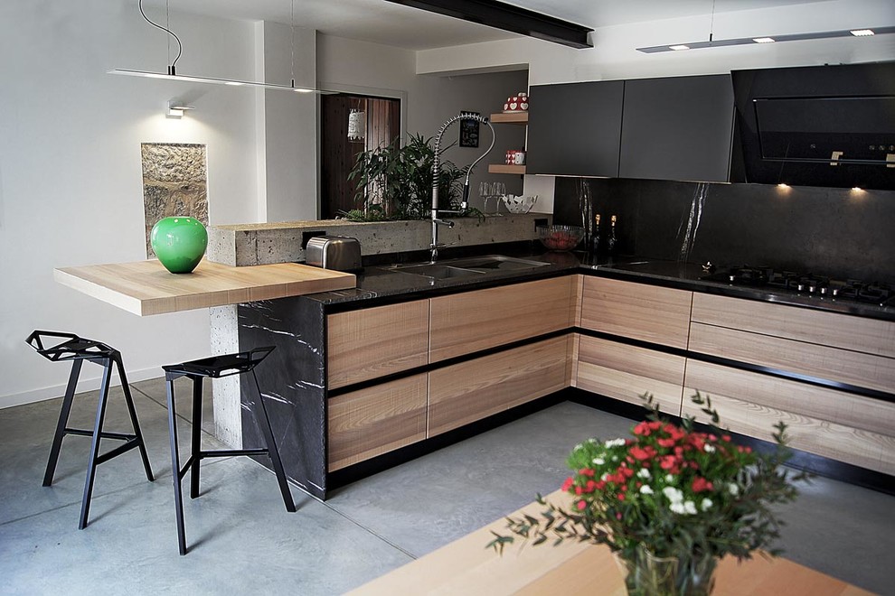 Idéer för att renovera ett funkis kök, med en enkel diskho, skåp i mellenmörkt trä, marmorbänkskiva, betonggolv och en halv köksö