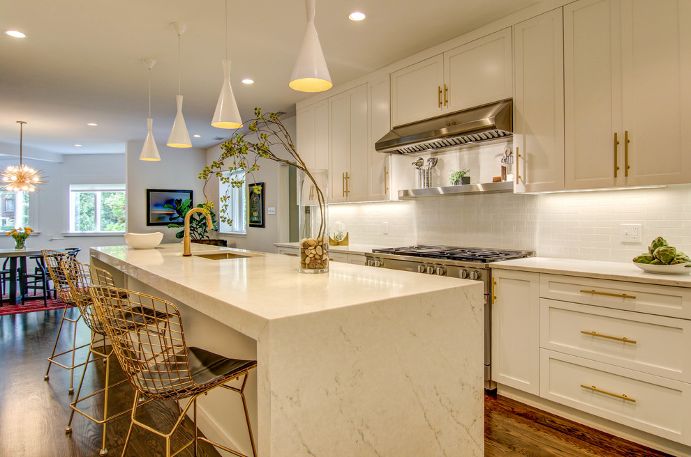 Eat-in kitchen - large eclectic l-shaped dark wood floor and brown floor eat-in kitchen idea in St Louis with an undermount sink, shaker cabinets, white cabinets, marble countertops, white backsplash, subway tile backsplash, stainless steel appliances and an island