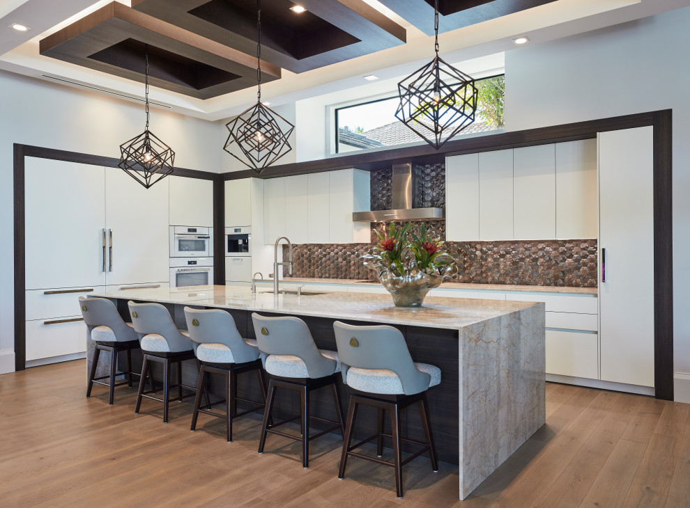 Example of a trendy l-shaped medium tone wood floor, brown floor and tray ceiling eat-in kitchen design in Miami with an undermount sink, flat-panel cabinets, white cabinets, brown backsplash, white appliances, an island and beige countertops