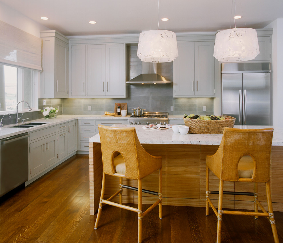 Example of a trendy l-shaped eat-in kitchen design in San Francisco with stainless steel appliances, shaker cabinets, gray cabinets, gray backsplash, an undermount sink, granite countertops and metal backsplash