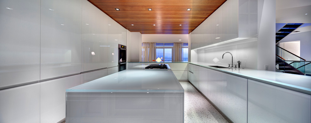 Esempio di una cucina moderna con ante lisce, ante bianche e top in vetro