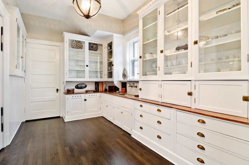 Immagine di una piccola cucina lineare design chiusa con ante di vetro, ante bianche, top in legno, lavello a vasca singola, parquet scuro e pavimento marrone