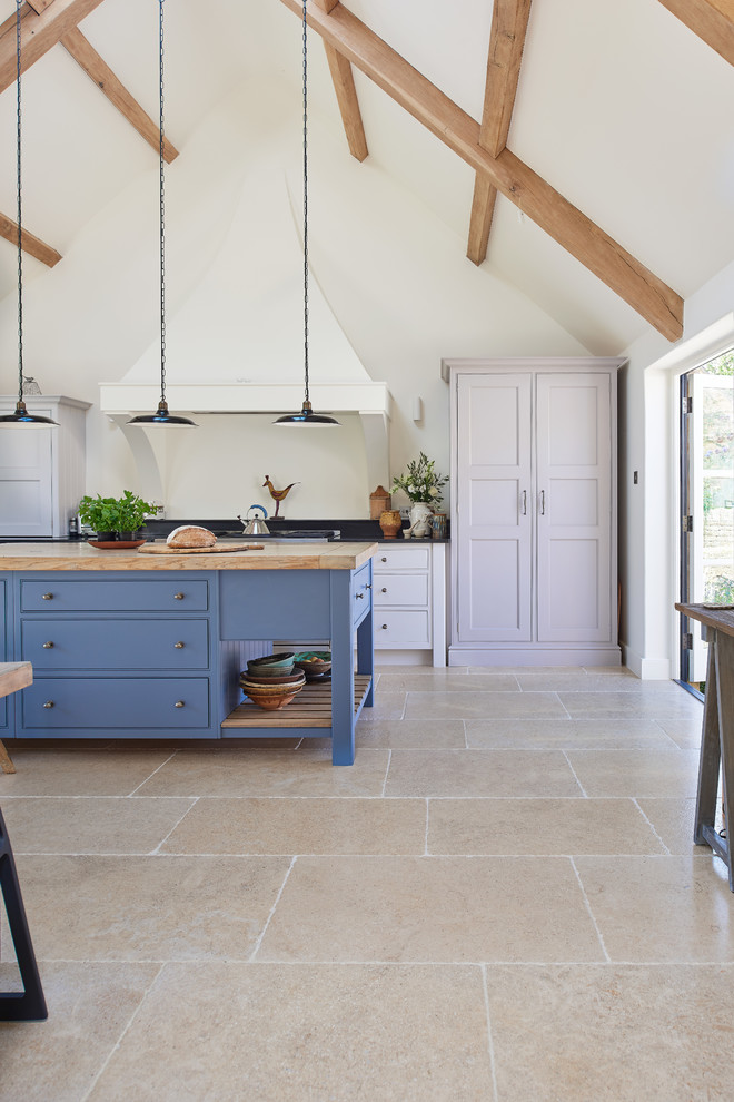 ウィルトシャーにあるカントリー風のおしゃれなキッチン (ライムストーンの床、フラットパネル扉のキャビネット、白いキャビネット) の写真