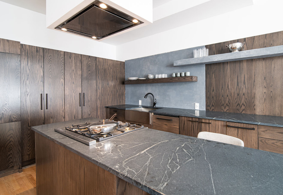 Inspiration for a medium sized contemporary l-shaped kitchen/diner in Newark with a belfast sink, flat-panel cabinets, dark wood cabinets, soapstone worktops, an island and grey worktops.