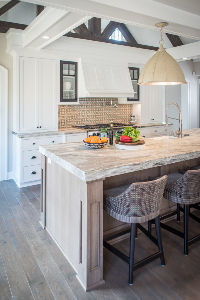 Example of a mid-sized transitional l-shaped medium tone wood floor eat-in kitchen design in Cleveland with a farmhouse sink, beaded inset cabinets, white cabinets, granite countertops, multicolored backsplash, terra-cotta backsplash, stainless steel appliances and an island