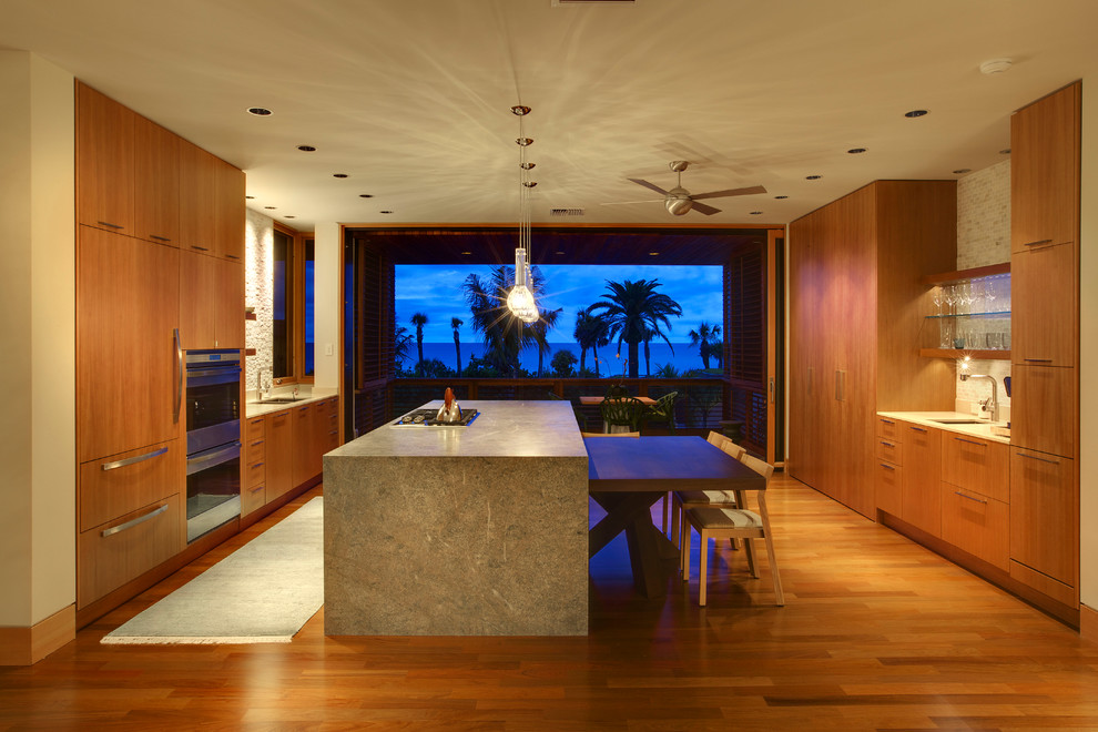 Zweizeilige Moderne Küche mit flächenbündigen Schrankfronten, hellbraunen Holzschränken, Küchenrückwand in Beige und Elektrogeräten mit Frontblende in Tampa