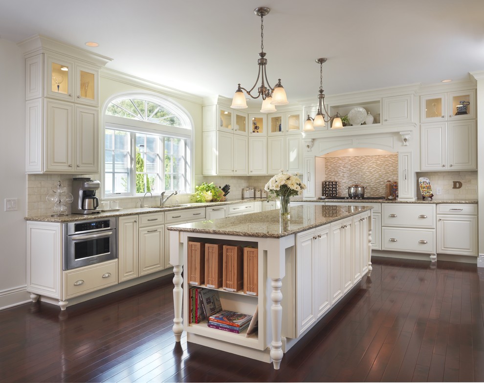 Example of a classic medium tone wood floor kitchen design in Providence with mosaic tile backsplash, granite countertops, beige backsplash, white cabinets and raised-panel cabinets