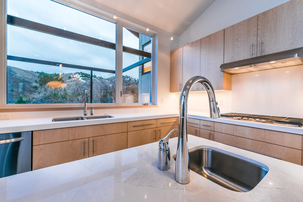 Inspiration for a large modern l-shaped open concept kitchen remodel in Salt Lake City with a farmhouse sink, flat-panel cabinets, light wood cabinets, granite countertops, stainless steel appliances and an island