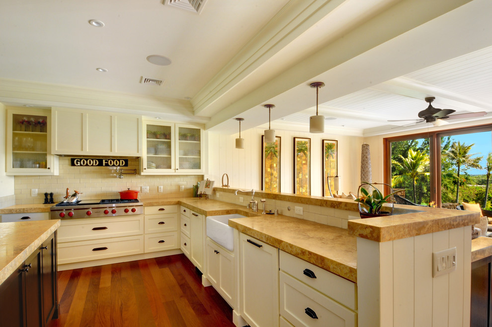 This is an example of a traditional kitchen in Hawaii with glass-front cabinets, stainless steel appliances and a belfast sink.