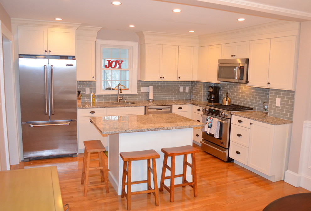 Mid-sized arts and crafts l-shaped medium tone wood floor eat-in kitchen photo in Boston with an undermount sink, shaker cabinets, white cabinets, granite countertops, green backsplash, glass tile backsplash, stainless steel appliances and an island