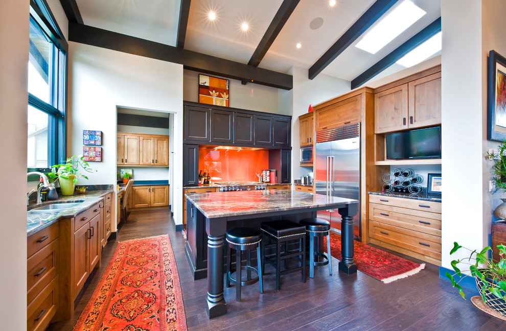 Cette image montre une cuisine traditionnelle en U et bois brun avec un plan de travail en granite, une crédence orange et un électroménager en acier inoxydable.